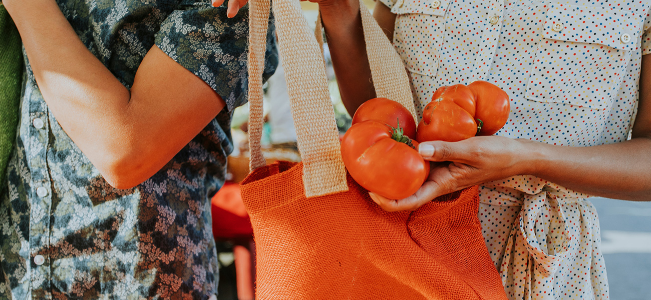 Lady buying fresh tomatoes at the farmer’s market.
