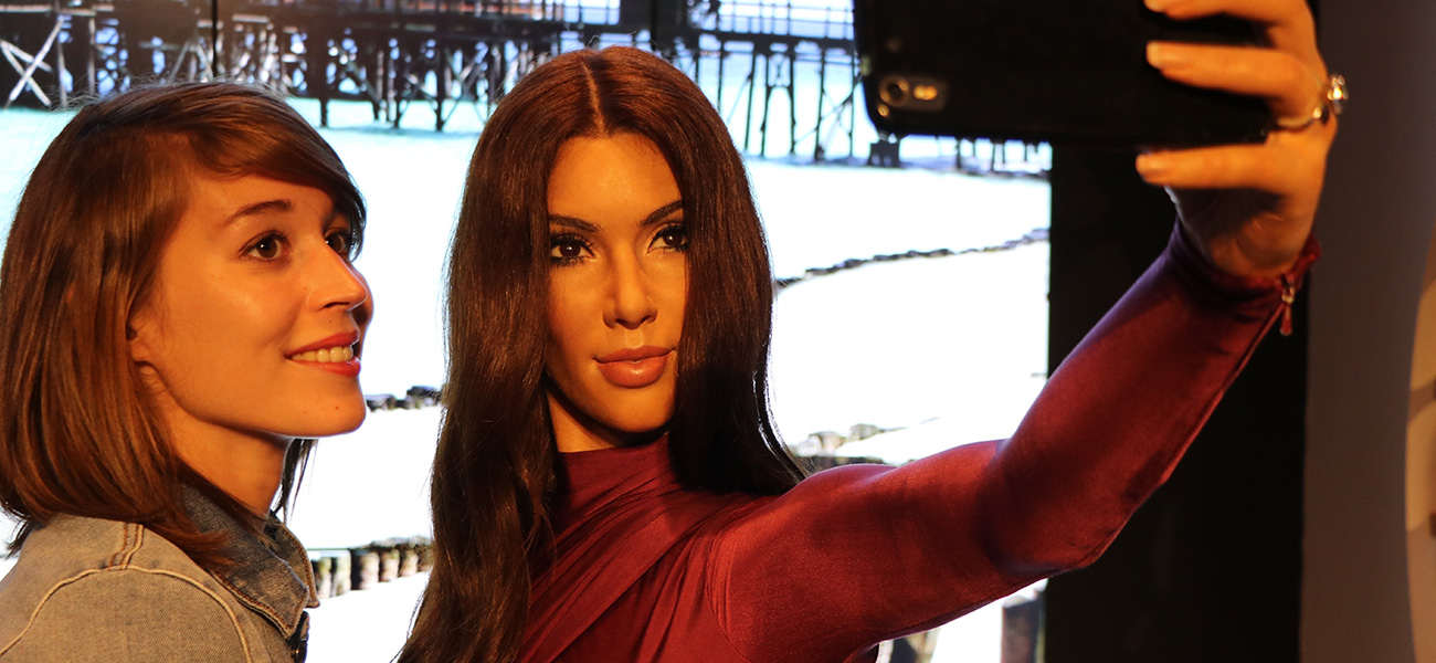 Lady posing with Kim Kardashian wax figure.