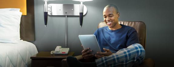 man on ipad using wifi in hotel room